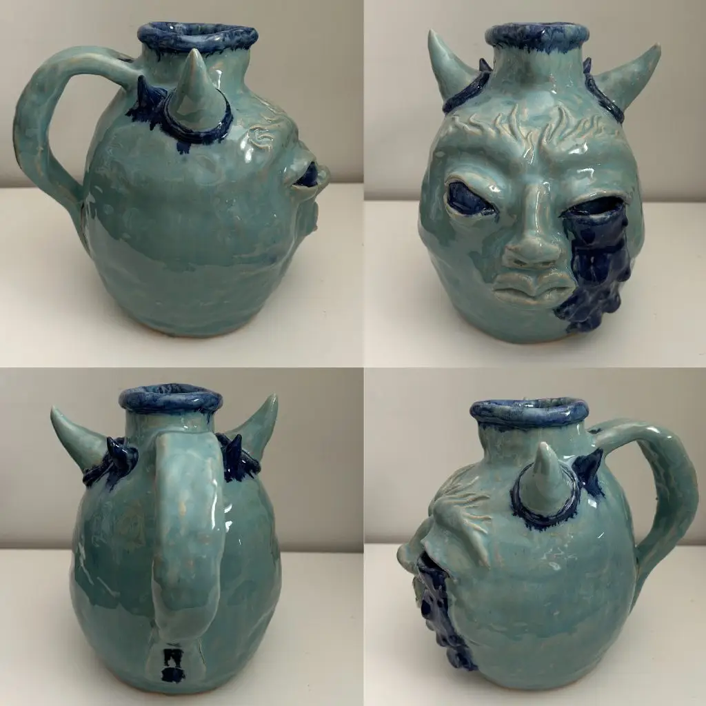 Ceramic jug with face and horns, dipped in celadon with cobalt blue.